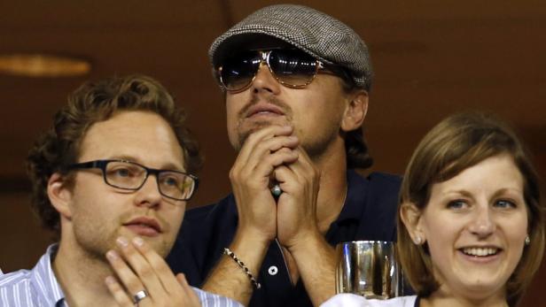 Leonardo DiCaprio mit zwei Begleitern bei einer Veranstaltung.