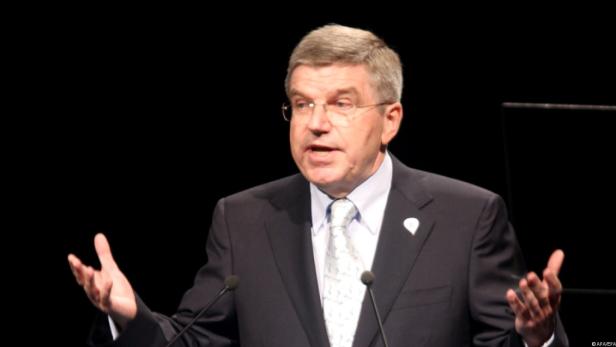Thomas Bach hält eine Rede vor einem dunklen Hintergrund.