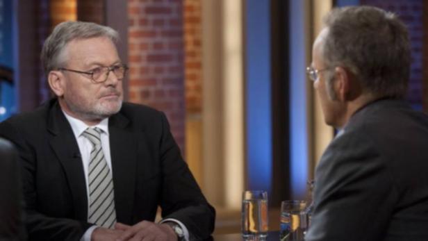 Zwei Männer sitzen sich in einem Fernsehstudio gegenüber und unterhalten sich.