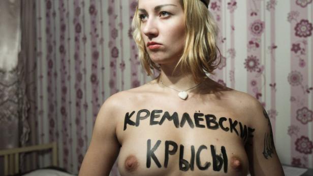 An activist of Ukrainian group Femen stands in a flat as she prepares for an action at the Sunday&#039;s presidential election in Moscow, March 3, 2012. Vladimir Putin sought a convincing victory in Russia&#039;s presidential election on Sunday to strengthen his hand in dealing with the biggest opposition protests since he rose to power 12 years ago. Critics question the legitimacy of a vote they say is skewed to help the former KGB spy return to the Kremlin after four years as prime minister, and are threatening to step up protests that began after a disputed parliamentary poll in December. The text reads: &#039;Kremlin Rats.&#039; Picture taken March 3, 2012. Reuters/Denis Sinyakov (RUSSIA - Tags: POLITICS ELECTIONS CIVIL UNREST) TEMPLATE OUT.