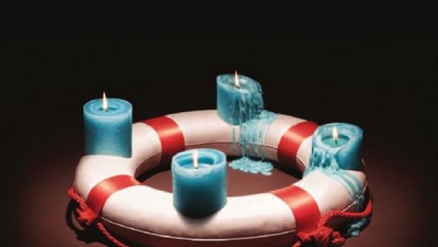 Ein Rettungsring mit vier blauen, brennenden Kerzen als Symbol für Hoffnung und Hilfe der Diakonie.