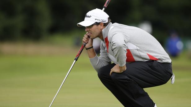 Ein Golfspieler kauert und zielt mit seinem Putter auf dem Grün.