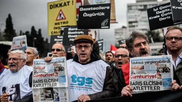 Eine Demonstration mit Menschen, die Zeitungen und Schilder mit türkischen Aufschriften halten.