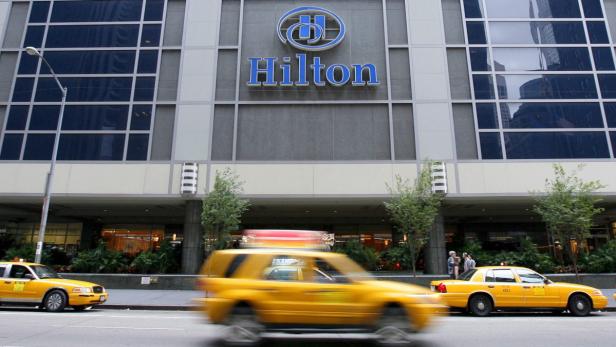 Ein Hilton Hotel mit gelben Taxis davor.