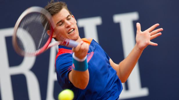 Ein Tennisspieler schlägt einen Ball mit seinem Schläger.