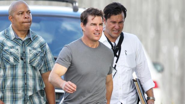 Tom Cruise geht mit zwei Begleitern die Straße entlang.