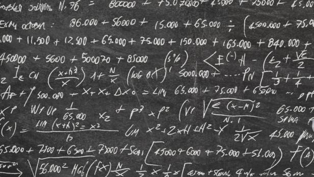 Eine Tafel voller komplexer mathematischer Formeln und Zahlen.