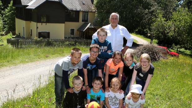 Direktor Hans Schaffer mit seinen Schülern aller Altersstufen vor der Volksschule Dreifaltigkeit.
