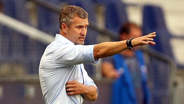 Ein Mann in einem hellblauen Hemd gestikuliert mit der rechten Hand.