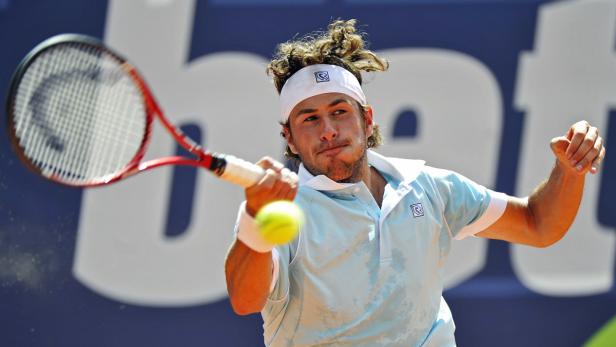 Ein Tennisspieler schlägt einen Ball mit seinem Schläger.
