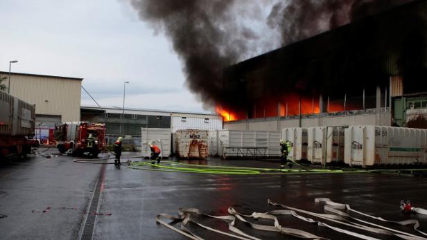 Ein Brand in einem Industriegebäude, Feuerwehrleute sind im Einsatz.