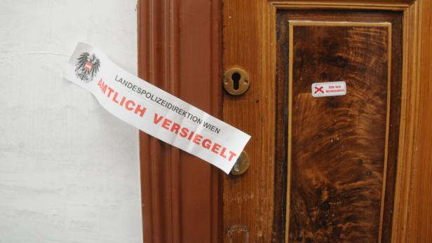 Eine Tür ist mit einem Siegel der Landespolizeidirektion Wien versehen.