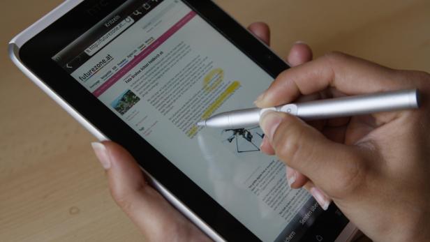 Eine Person markiert Text auf einem Tablet mit einem Stift.