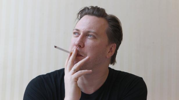 Ein Mann mit blauem Blick raucht eine Zigarette.