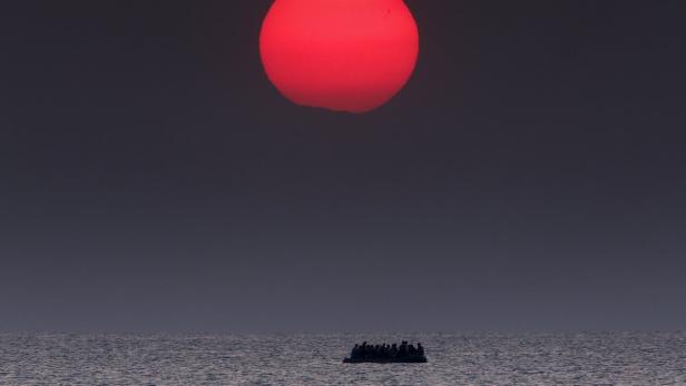 Ein Boot mit Menschen auf dem Meer unter einer roten Sonne.