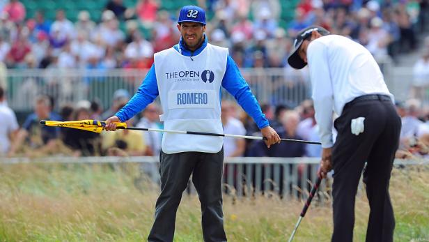 Ein Caddie namens Romero hält eine Fahnenstange während eines Golfturniers.