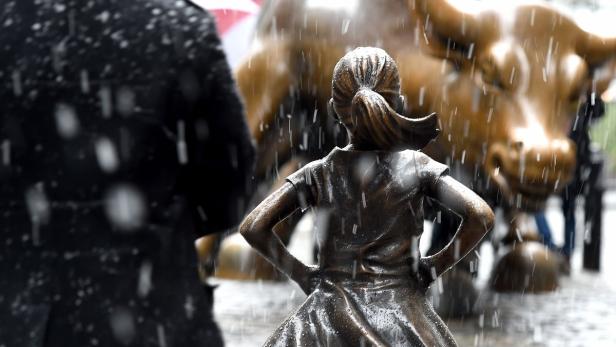 Die „Fearless Girl“-Statue steht im Regen dem Charging Bull an der Wall Street gegenüber.