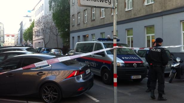 Ein Tatort in einer Stadt mit einem Polizeiwagen und Absperrband.