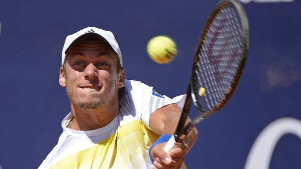 Ein Tennisspieler schlägt einen Ball mit seinem Schläger.
