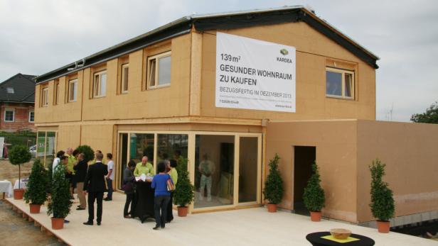 Ein zweistöckiges Haus mit einem Schild, das für gesunden Wohnraum wirbt.