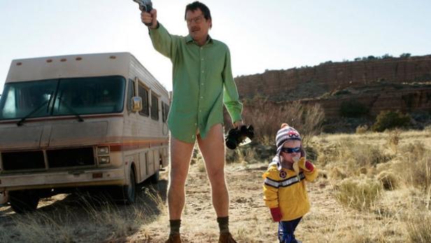 Walter White in Unterwäsche zielt mit einer Waffe, neben ihm ein Kind mit Sonnenbrille.