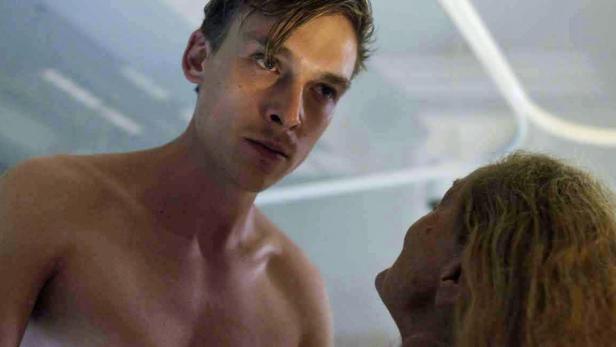 Ein junger Mann blickt aufmerksam auf eine ältere Person.