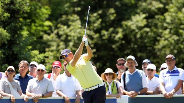 Ein Golfspieler schwingt seinen Schläger vor einer Zuschauermenge.