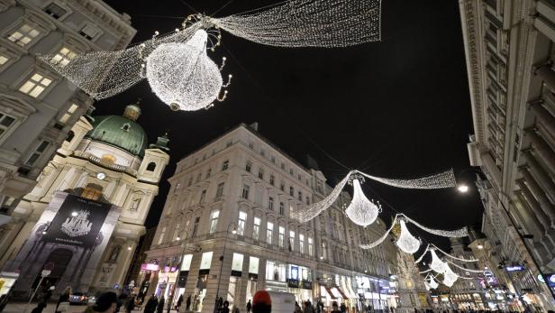Die Wiener Innenstadt ist weihnachtlich mit großen, leuchtenden Kronleuchtern geschmückt.