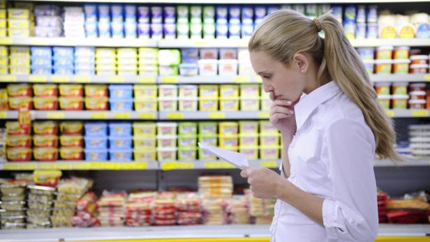 woman reading her shopping list in the supermarket with copy space