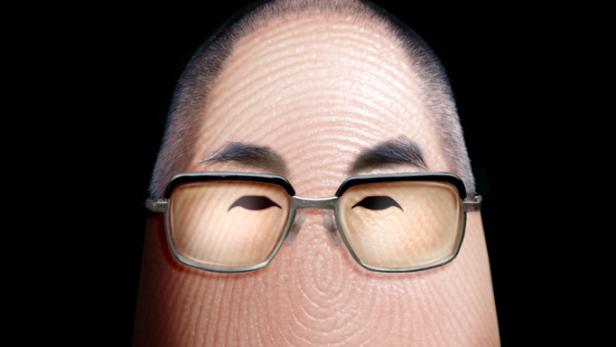 Ein Fingerabdruck, der wie der Dalai Lama aussieht, mit Brille und Schal vor schwarzem Hintergrund.