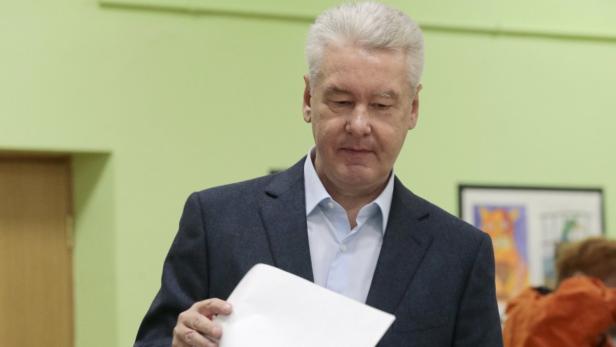 Sergei Sobjanin bei einer Wahlveranstaltung mit einem Stimmzettel in der Hand.