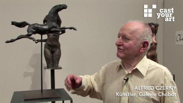 Alfred Czerny, Künstler, steht neben einer Skulptur von einem Pferd auf einer menschlichen Figur.