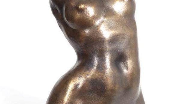 Eine bronzefarbene Skulptur eines weiblichen Torsos.