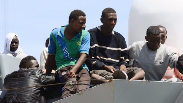 Mehrere Männer sitzen auf einem Schiff.