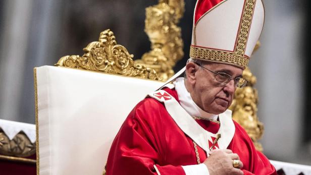 Papst Franziskus sitzt auf einem Thron.