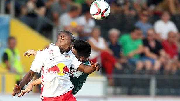 Zwei Fußballspieler kämpfen um den Ball während eines Spiels.