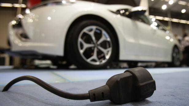 A power cable lies on the ground in front of an Opel Ampera at the Automechanika trade fair in Frankfurt September 11, 2012. REUTERS/Alex Domanski (GERMANY - Tags: SPORT MOTORSPORT BUSINESS)