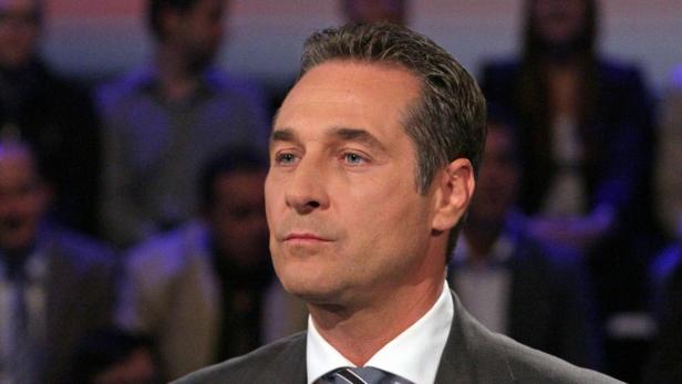 Ein Mann mit grau meliertem Haar und Anzug blickt aufmerksam zur Seite.