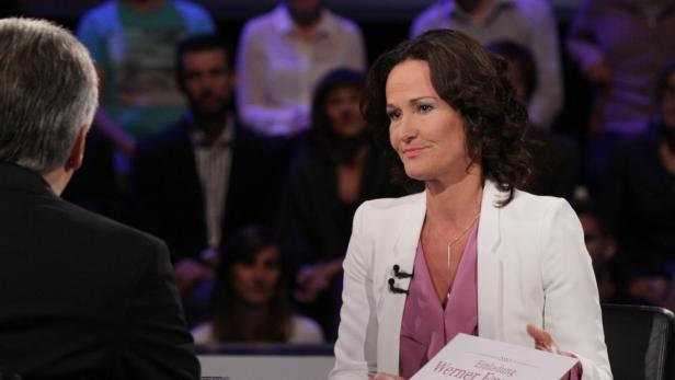 Eine Frau im Gespräch mit einem Mann im Studio.
