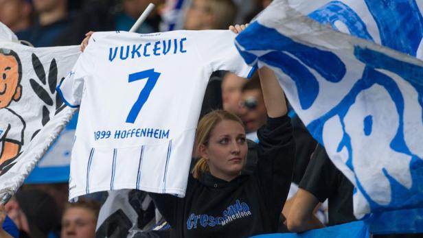 Eine Frau hält ein Trikot von Vukcevic (TSG Hoffenheim) mit der Nummer 7 hoch.