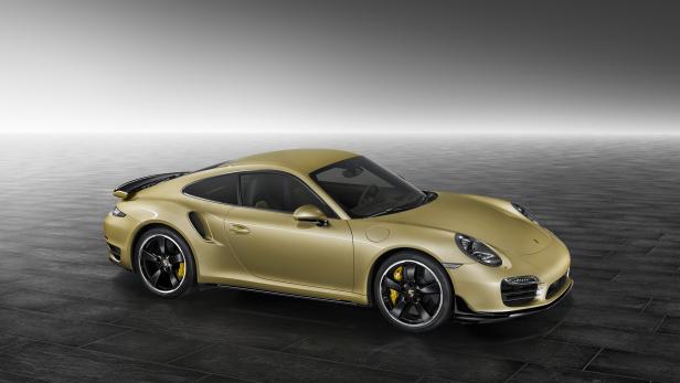 Ein goldener Porsche 911 Turbo steht in einem Studio.