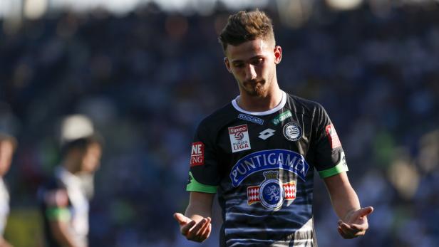 Ein Fußballspieler im Trikot von Sturm Graz mit fragendem Blick.
