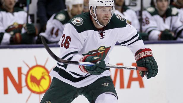 Ein Eishockeyspieler der Minnesota Wild in Aktion auf dem Eis.