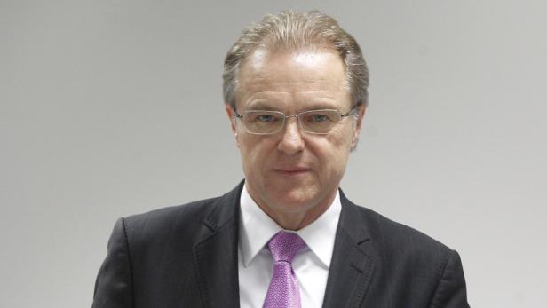 Ein Mann mit Brille, Anzug und Krawatte blickt in die Kamera.