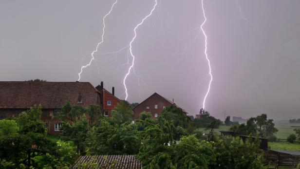 Mehrere Blitze schlagen in der Nähe von Häusern ein.