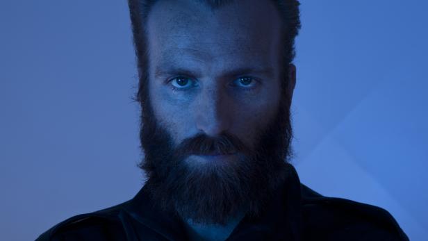 Porträt eines Mannes mit Bart im blauen Licht.