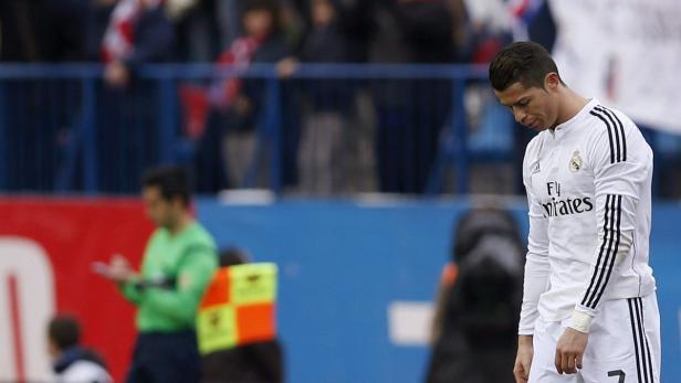 Cristiano Ronaldo in Sportkleidung mit gesenktem Kopf auf einem Fußballfeld.