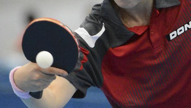 Ein Tischtennisspieler schlägt einen Ball mit einem Schläger.
