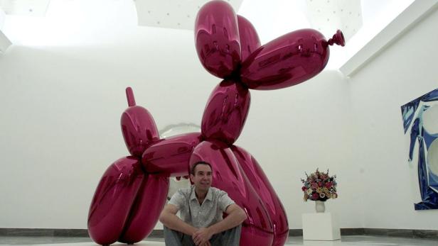 U.S. artist Jeff Koons sits by his sculpture called Ballon Dog, during the preparation of his exhibition in Naples, 06, June, 2003. The Jeff Koons&#039; exihbition will open on 9 June at National Musuem in Naples, southern Italy. REUTERS/ Mario Laporta