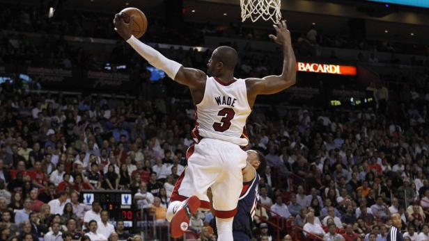 Miami Heat guard Dwyane Wade grabs an offensive rebound against Atlanta Hawks during their NBA game at the American Airlines Arena in Miami, Florida, March 12, 2013. REUTERS/Robert Sullivan (UNITED STATES - Tags: SPORT BASKETBALL)
